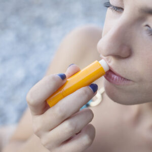 overhead-view-young-woman-applying-lip-balm